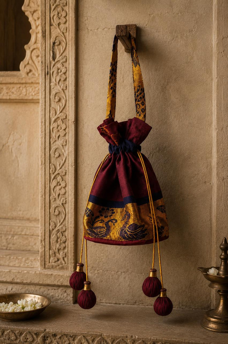 Decorative bag with intricate patterns hanging on a textured wall.